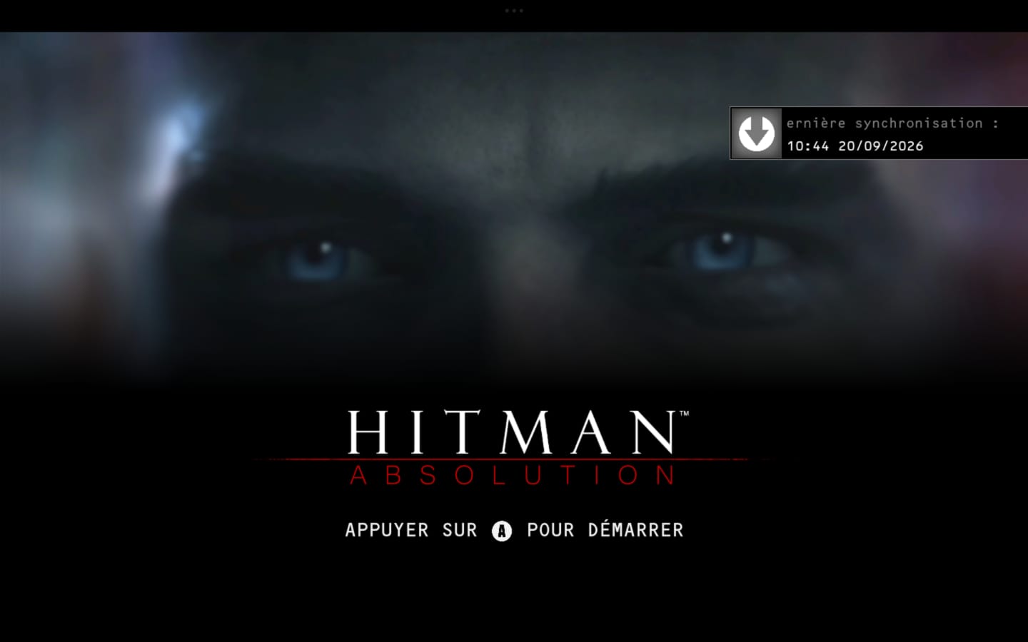 Pantalla de inicio de Hitman: Absolution en francés con la frase Appuyer sur A pour démarrer.